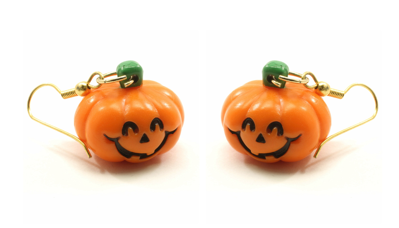 A pair of cute jack-o'-lantern pumpkin earrings, a fun accessory for a Halloween costume.