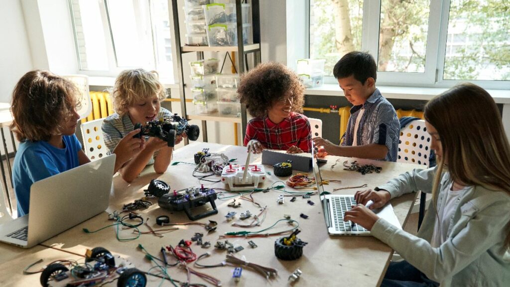 A group of children collaborating and building, playing with coding educational toys for kids.