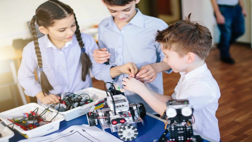 A group of children working together as a team to build a robot from a robotics kit.