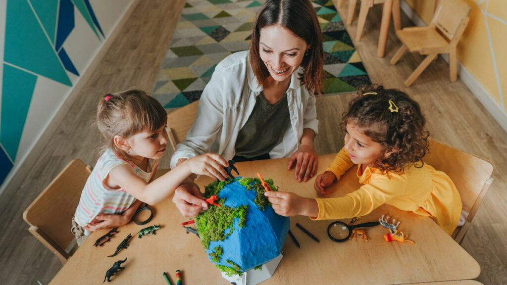A woman and several young children gathered around a table, happily working together on a creative craft project.