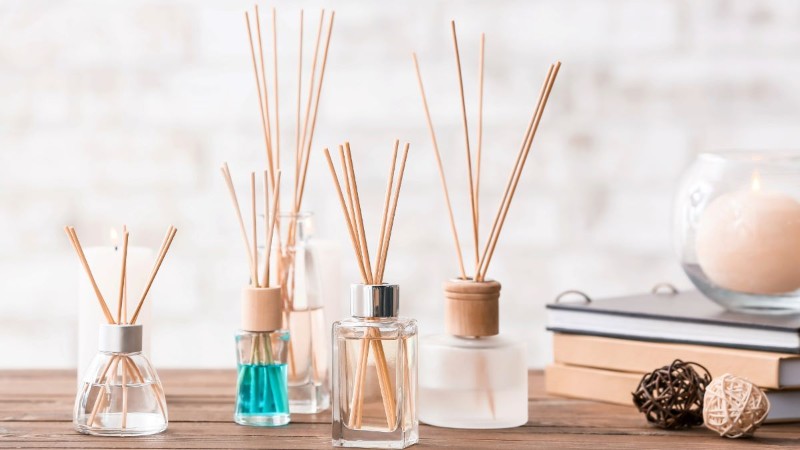Several glass reed diffusers filled with colorful scented oils, a popular and long-lasting way to make your home smell amazing.