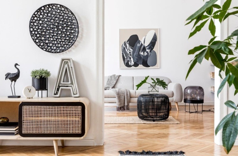 A stylish and modern living room with a wooden console table, abstract wall art, and a minimalist sofa in the background.