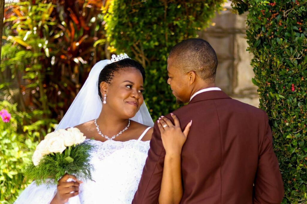A beautiful African bride in her wedding dress smiling at her groom, representing love and celebration in African wedding customs.