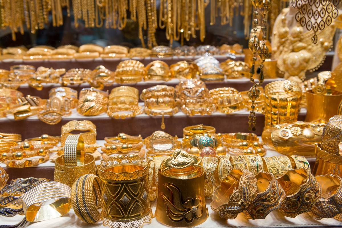 A lavish display of gold bracelets and necklaces in a market, representing the tradition of gifting valuable gold jewelry at Muslim weddings.