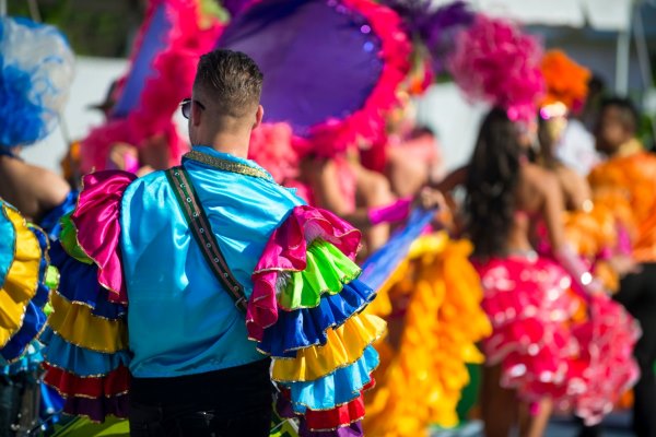 A colorful Brazilian celebration reminiscent of Carnival, with a person wearing a vibrant costume with bright feathers, representing a festive birthday tradition.
