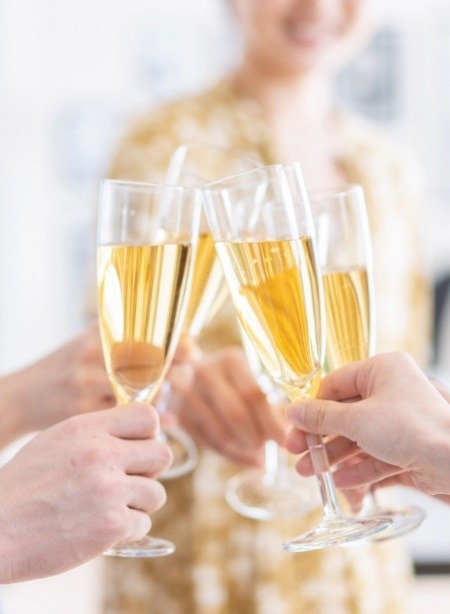 A group of people toasting with champagne flutes, a classic party tradition that has become a global symbol of celebration.