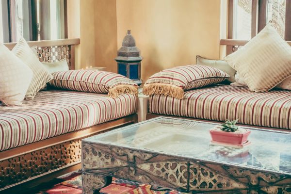 A modern Moroccan style living room, featuring two sofas, a glass table and a Morrocan lantern.